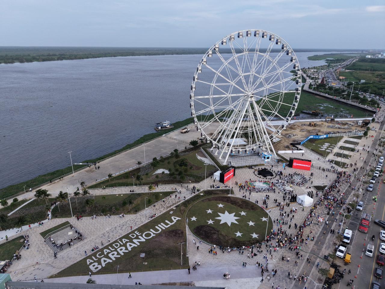 Vista aérea del gran malecón en el centro se destaca una enorme rueda de la fortuna la luna del Rio instalada sobre una plataforma y rodeada de senderos peatonales y zonas verdes.