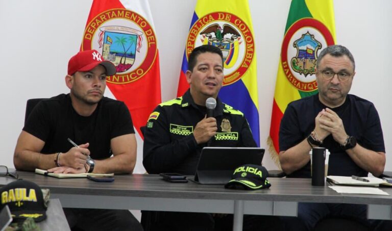 Policía metropolitana junto a directivos en un espacio oficial, con las banderas institucionales al fondo, lo que refleja el trabajo articulado.