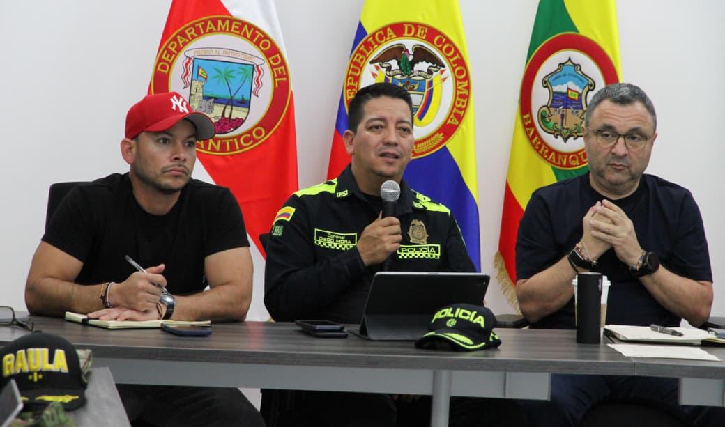 Policía metropolitana junto a directivos en un espacio oficial, con las banderas institucionales al fondo, lo que refleja el trabajo articulado.