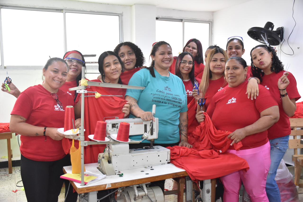 Mujeres reclusas participando en taller de confecciòn y posando para la foto.
