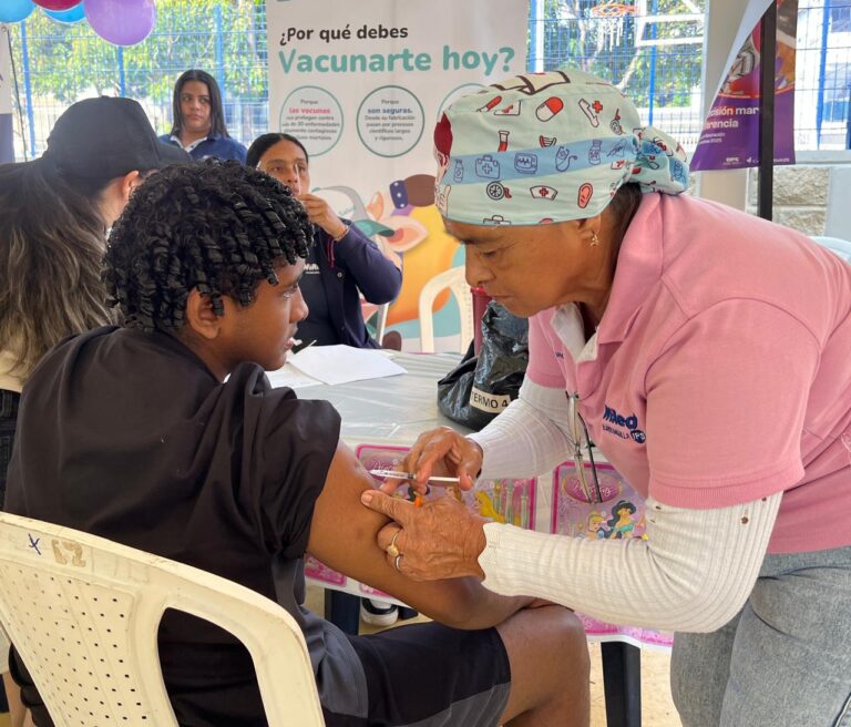 Enfermera aplicando dosis de vacuna a joven en brigadas de salud.