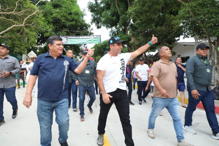 El Acalde Alejandro Char junto a funcionarios y directivos caminan mientras saludan.