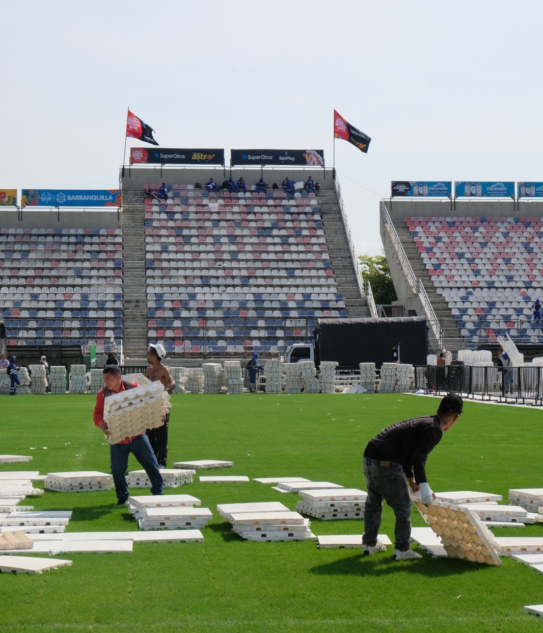 Personal hace desmonte en el gramado del Estadio Romelio, retirando silletería y tablones de plástico