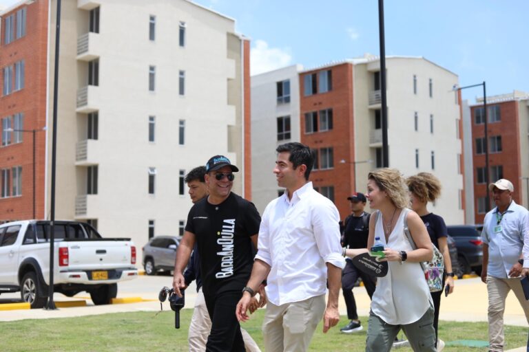 Alcalde camina por edificios residenciales junto a personas