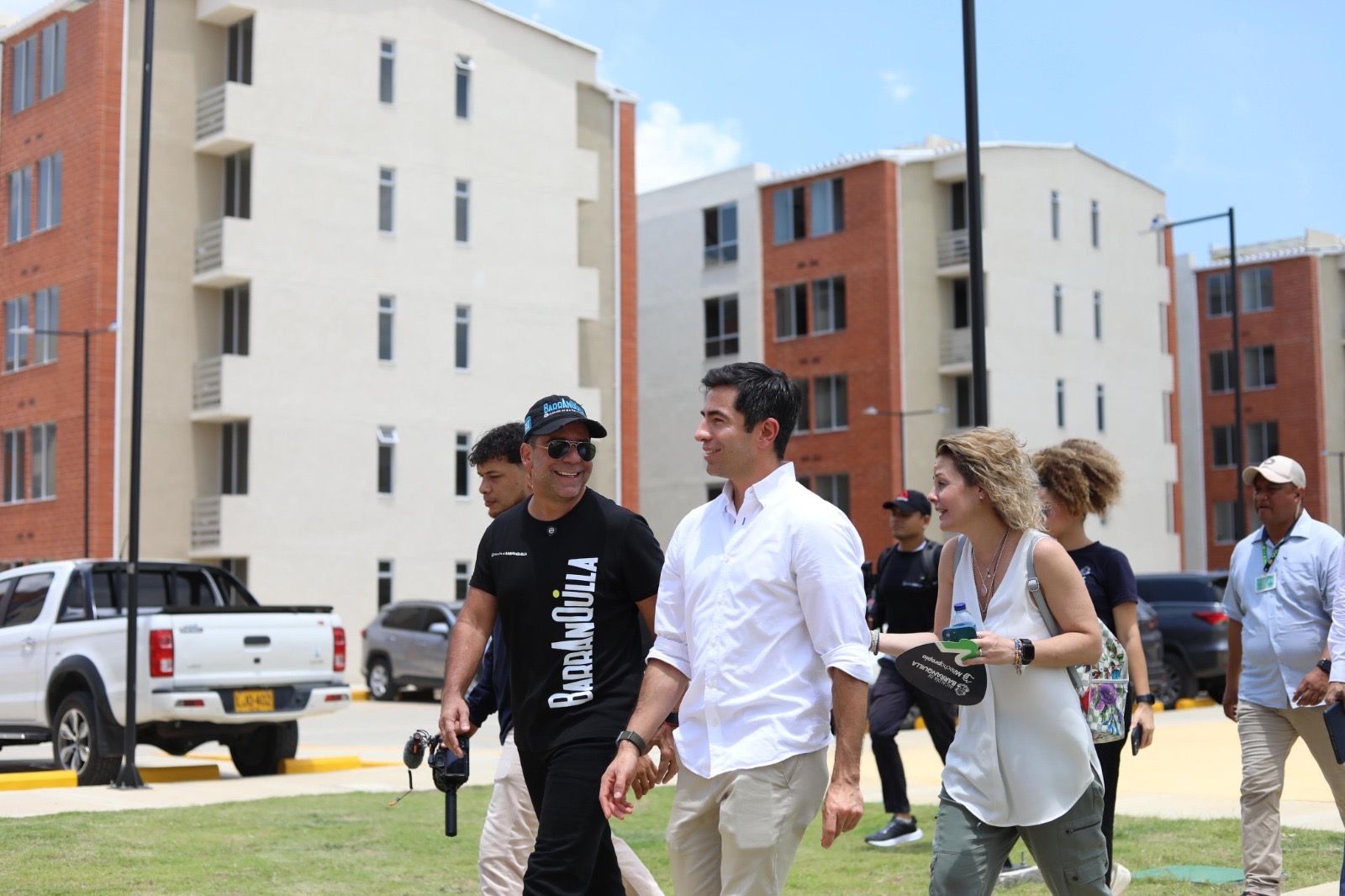 Alcalde camina por edificios residenciales junto a personas