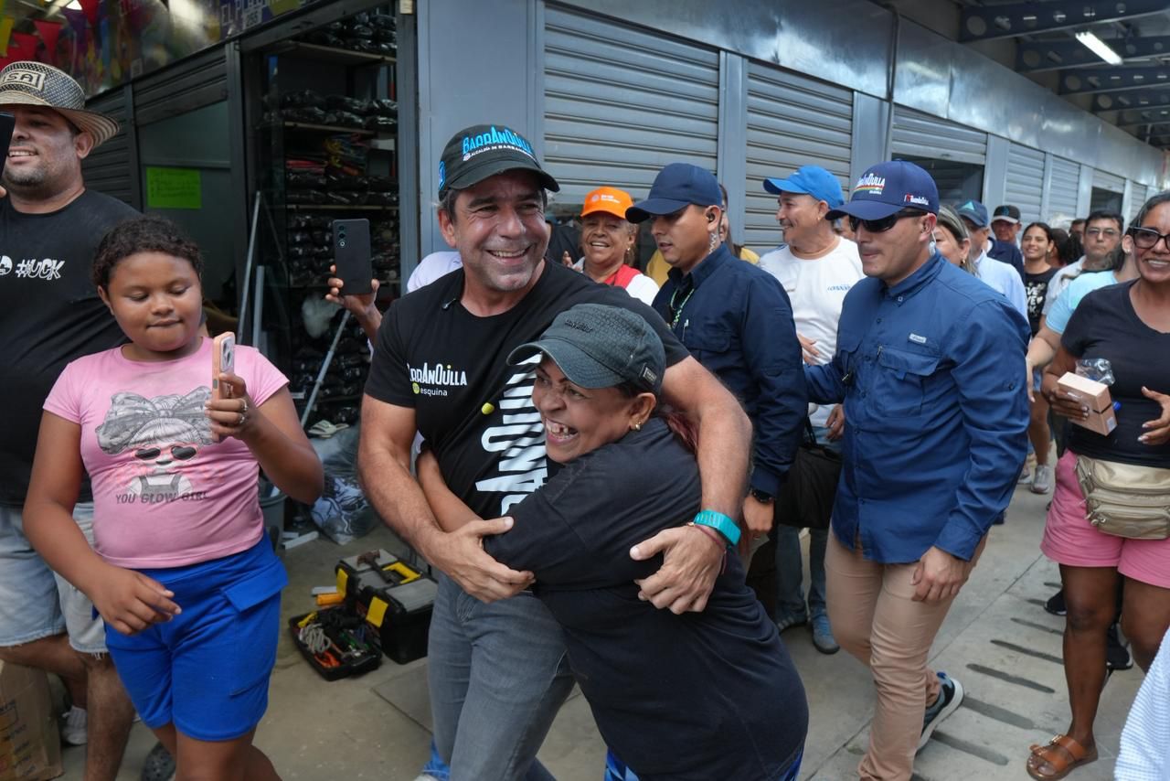 Alcalde caminando con los comerciantes de El Playón, es abrazado por una beneficiaria