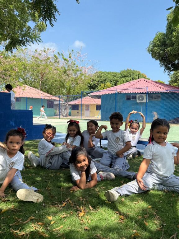 estudiantes sentados en la grana del colegio