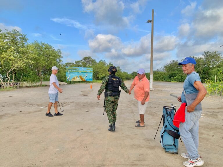 Mujer del Gaula conversa con personas en una vía veredal sin pavimentar