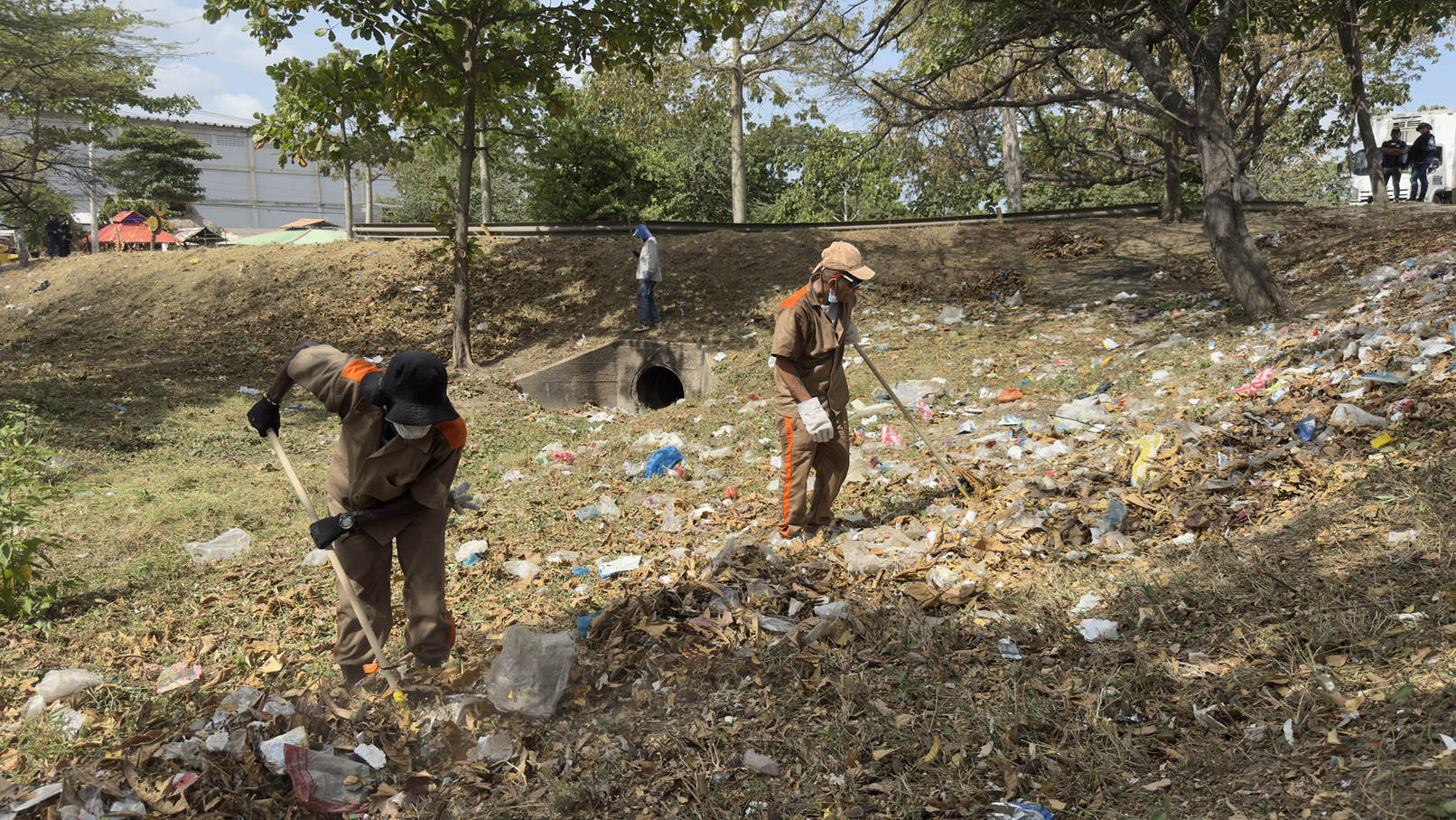 reclusos limpian punto crítico con escobas y azadones