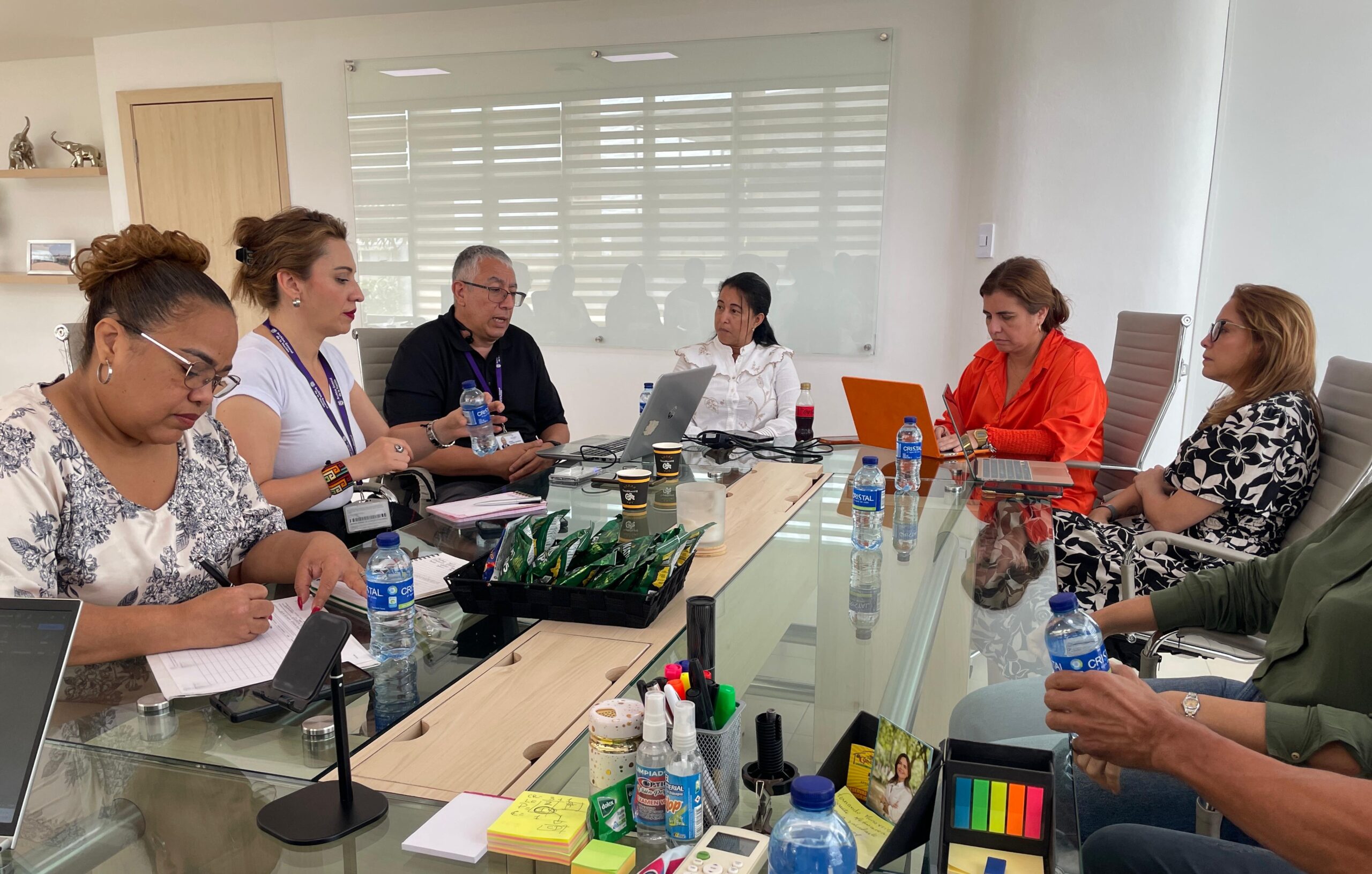 Equipo de funcionarios reunidos en mesa redonda.